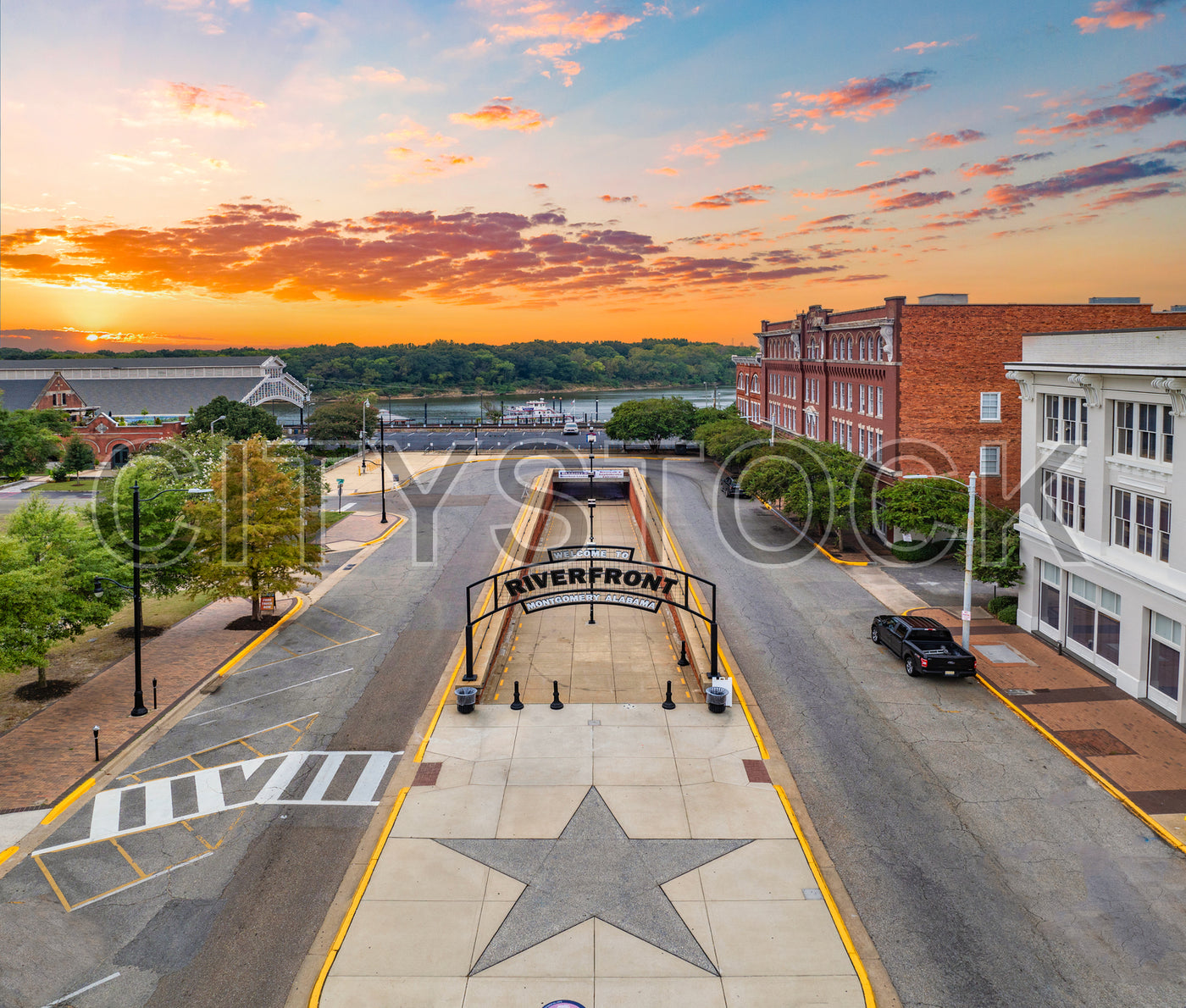 Sunset view of Montgomery Riverfront with vibrant sky and city buildings