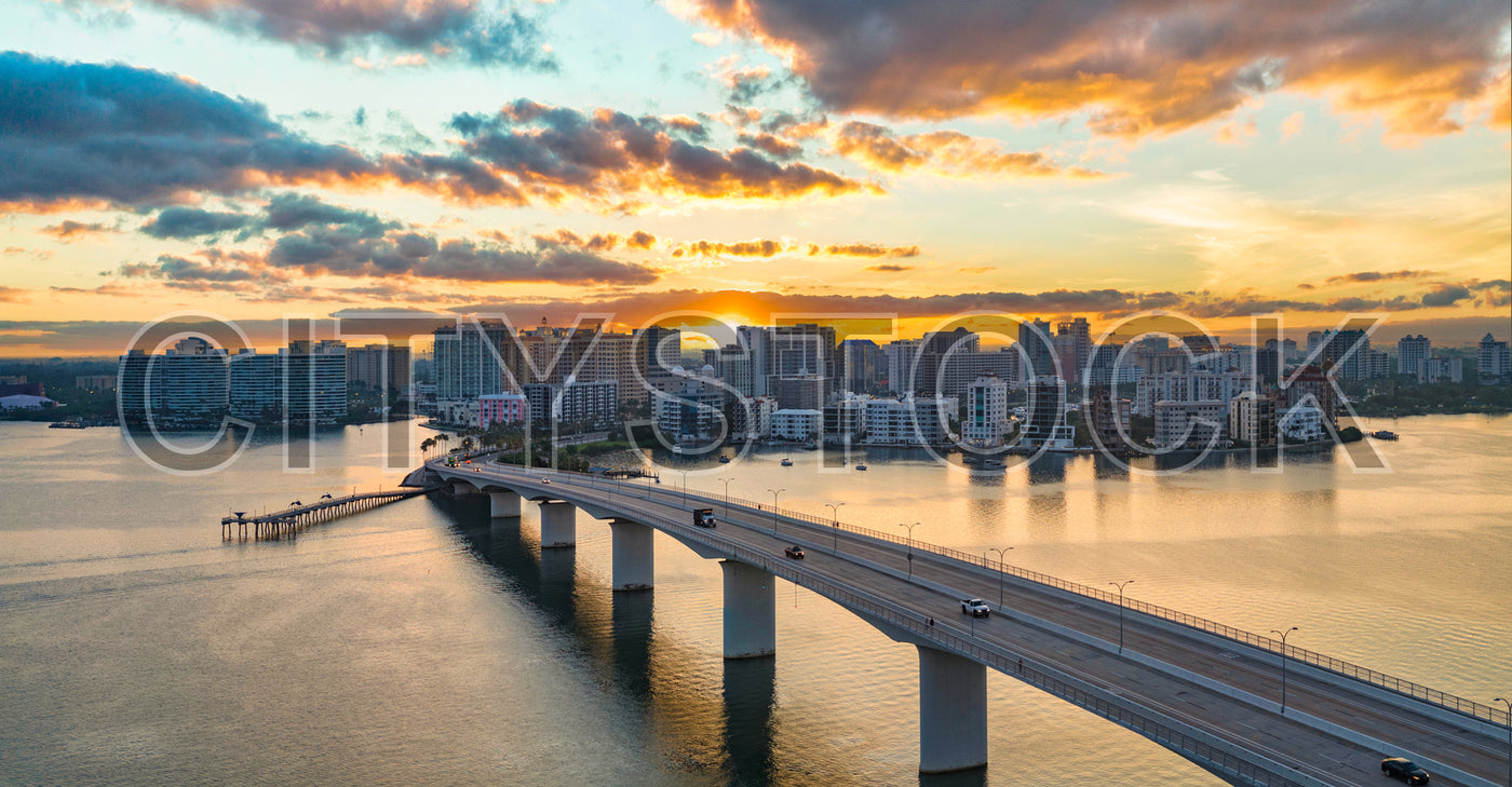 Stunning sunset view of Sarasota skyline and Ringling Bridge over calm bay waters