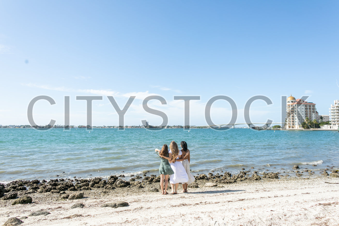 Family embracing, enjoying Sarasota's sunny coastal view