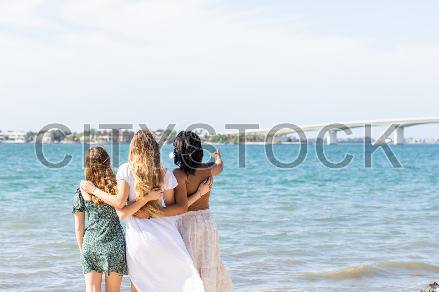 Friends lovingly hugging, overlooking Sarasota bay