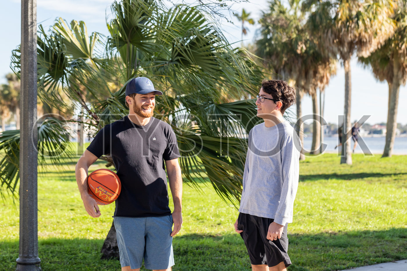 Two young adults enjoying a basketball game on a sunny day in St Petersburg