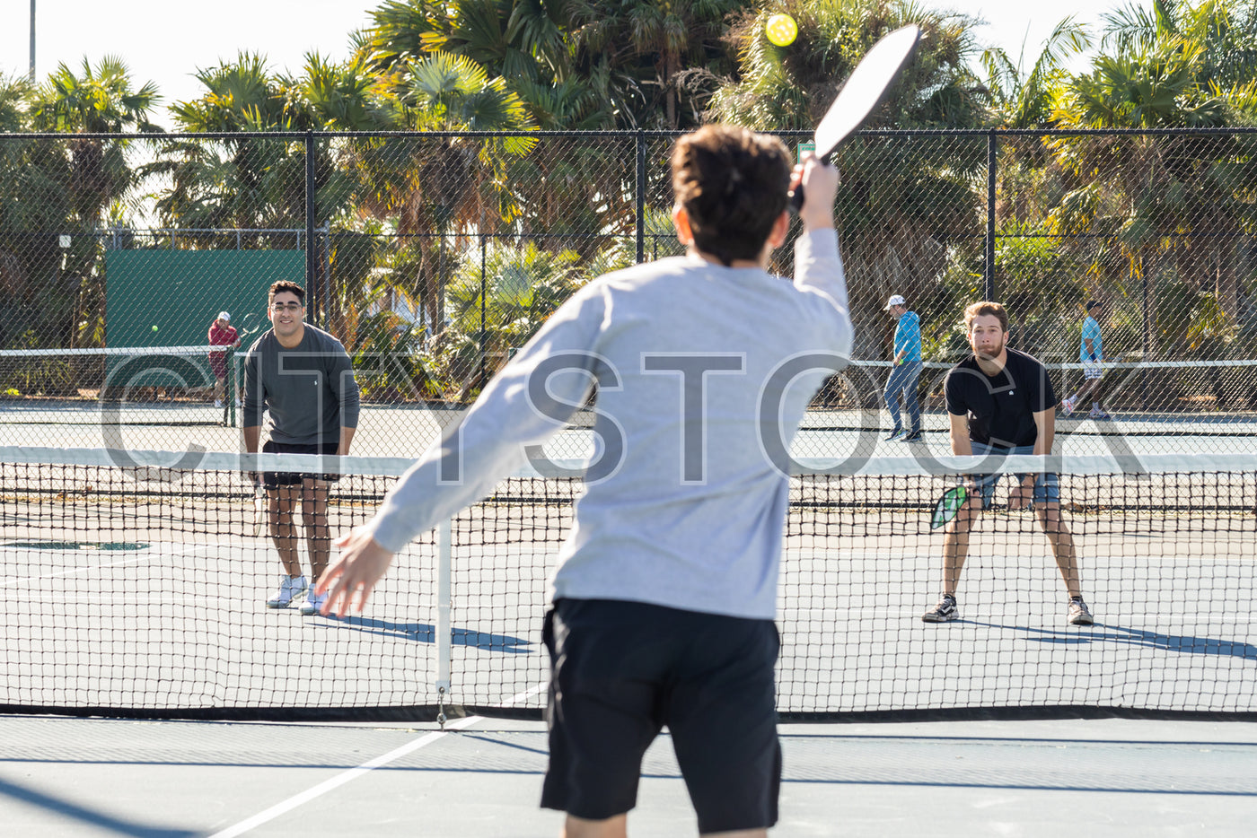 Men playing paddle tennis on a sunny day in St Petersburg