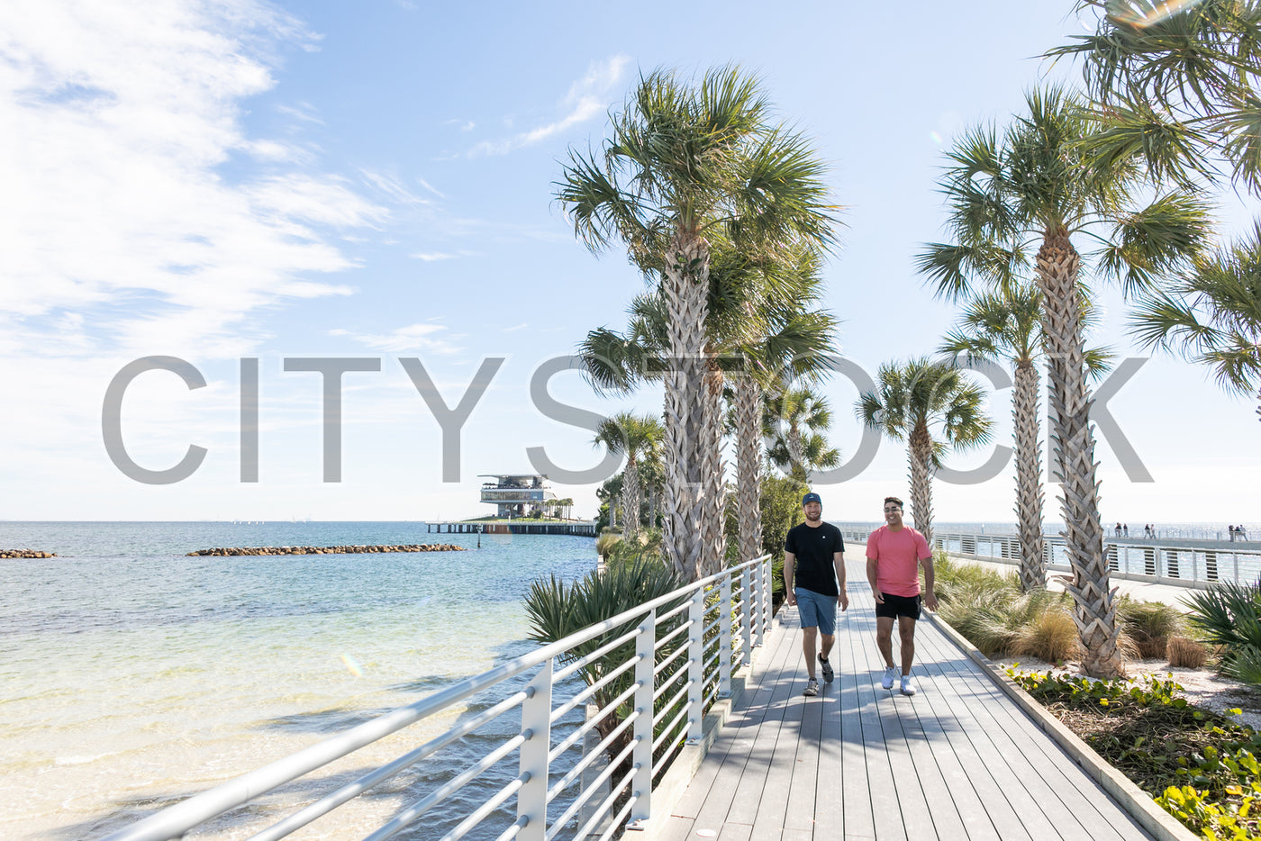 Couple walking on sunny boardwalk in St. Petersburg, FL