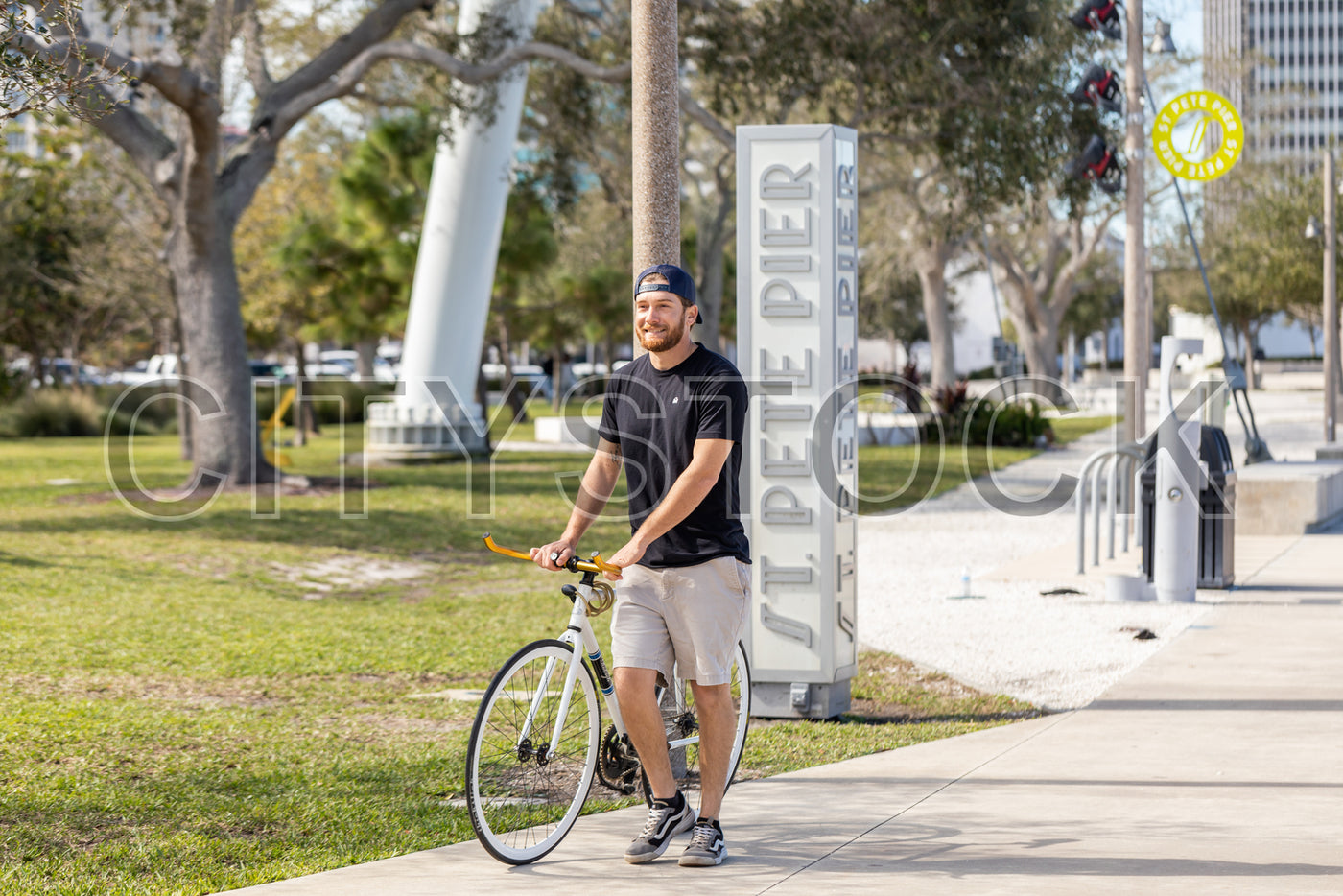 Young man cycling in St. Petersburg park on sunny day