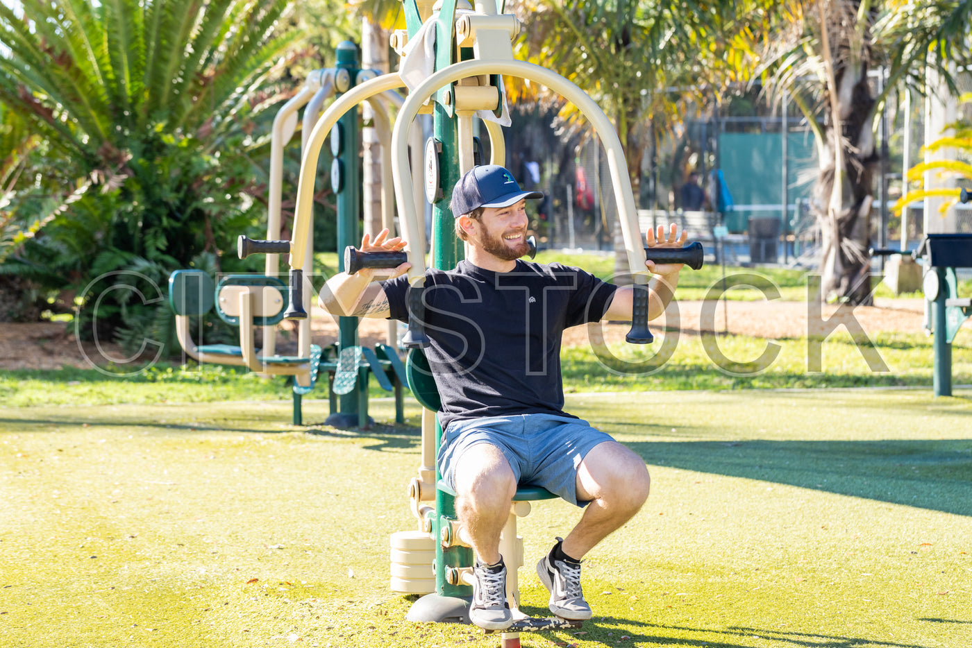 Man smiling while exercising at outdoor gym in St Petersburg park