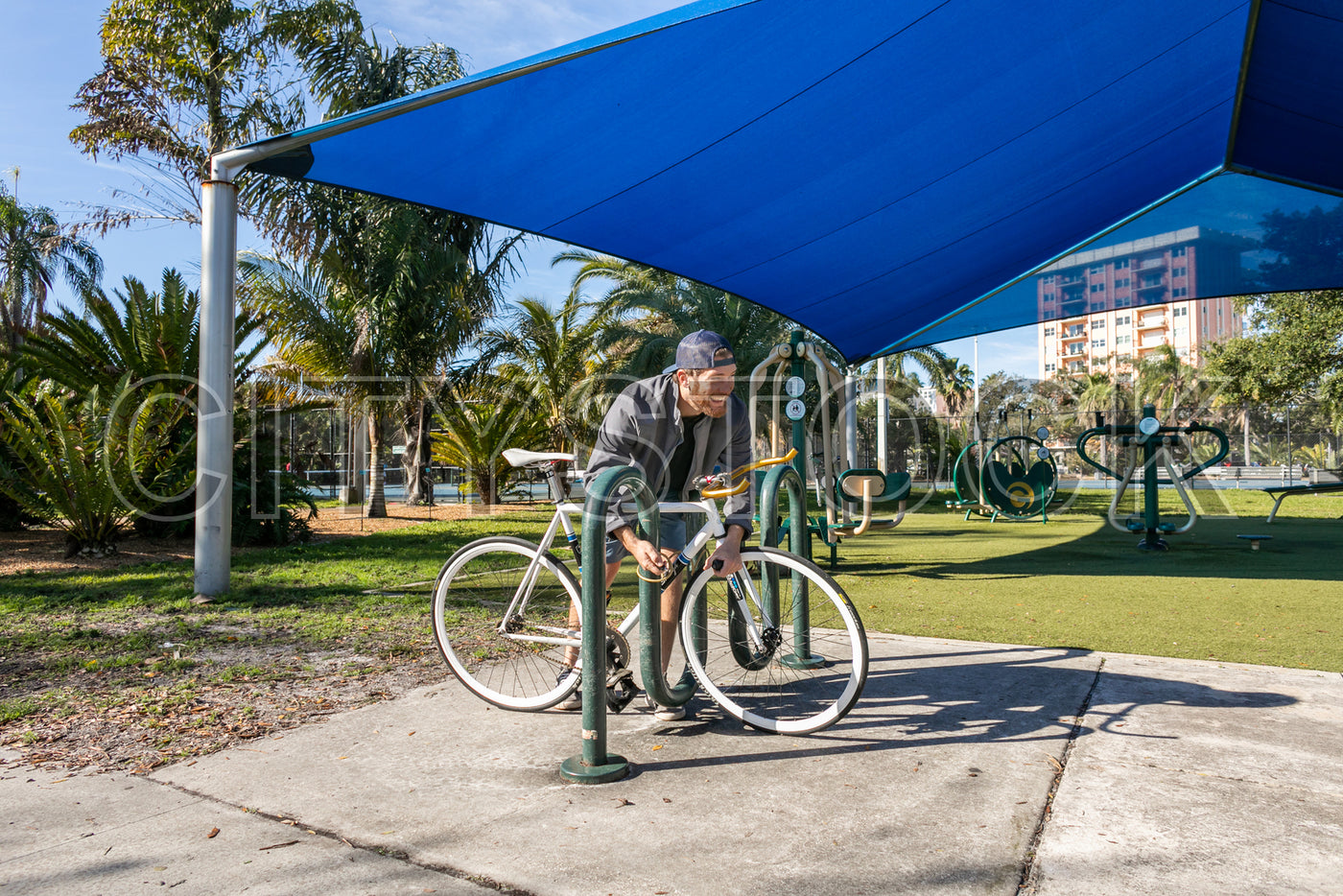 Senior man exercising on outdoor fitness bike in park in St Petersburg