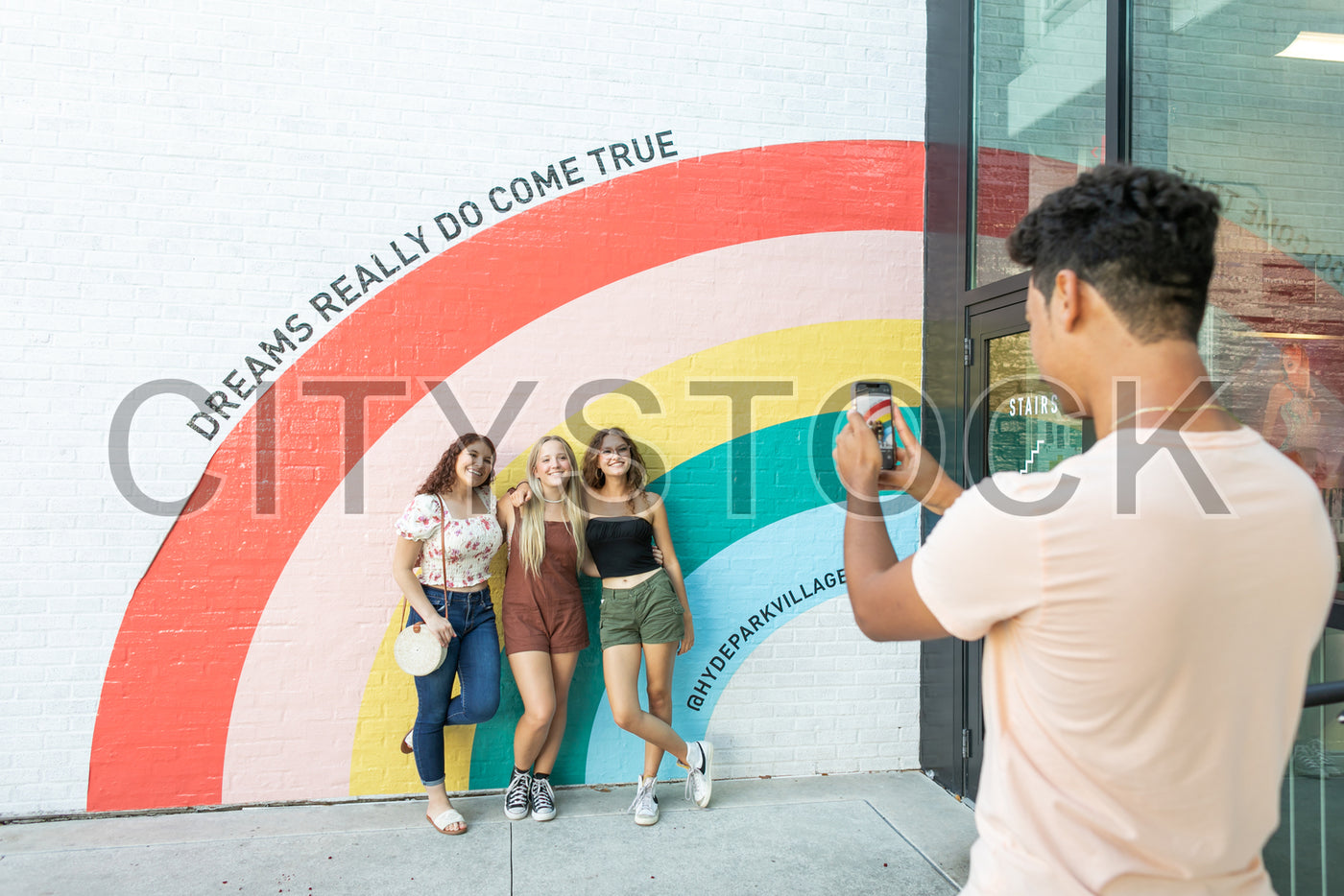 Friends posing in front of a vibrant mural in Tampa, Florida