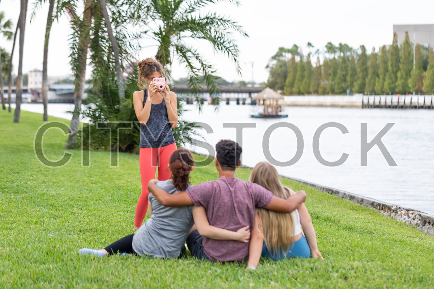 Young friends enjoying a sunny day at scenic Tampa waterfront with camera