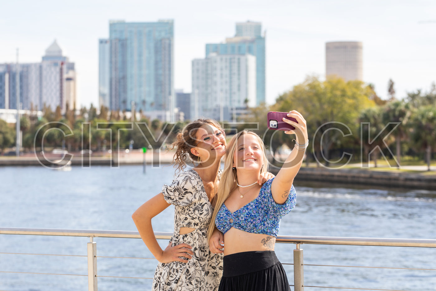 Joyful young women capturing selfie with Tampa skyline in the background