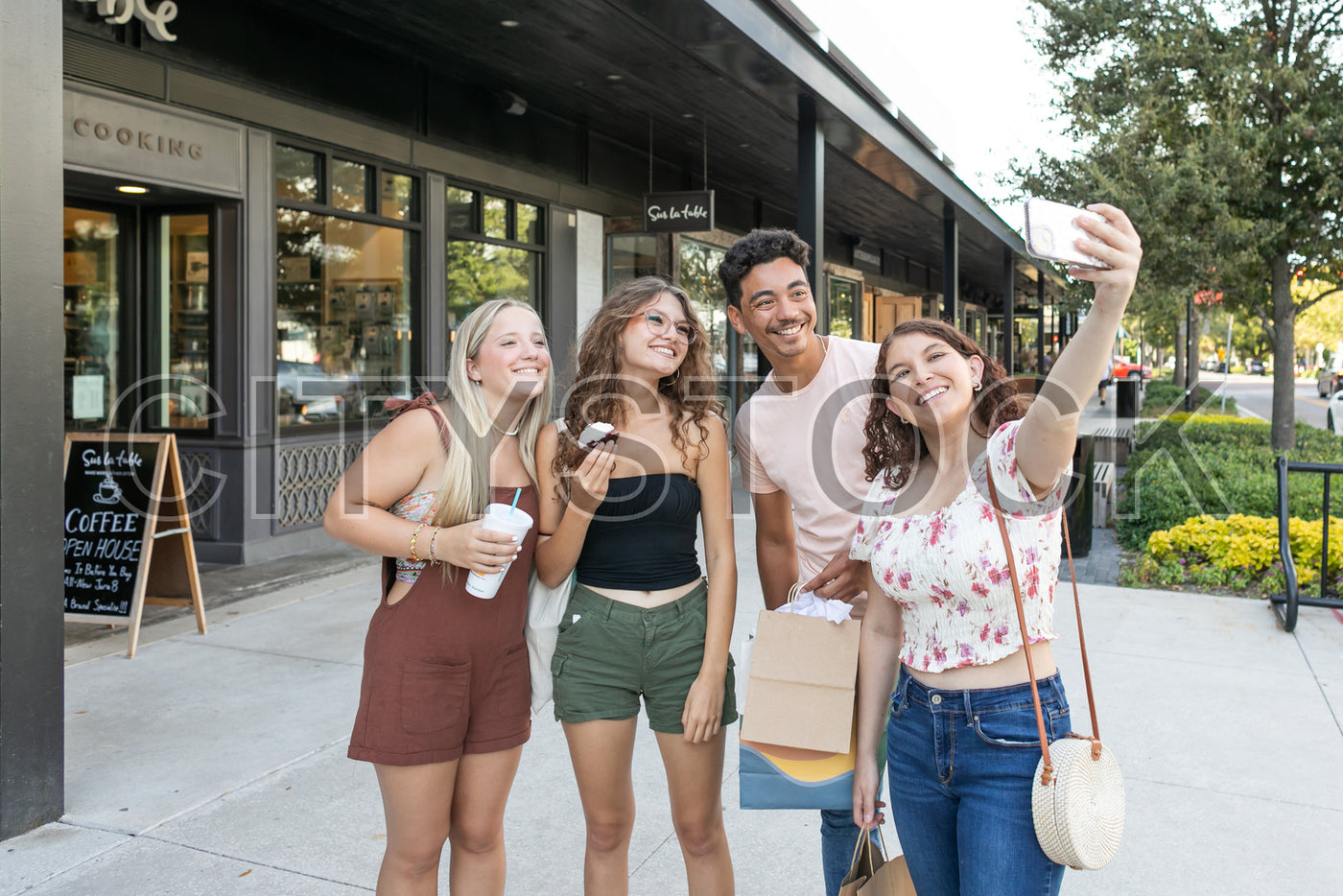 Group of four friends taking a selfie in front of a Tampa coffee shop