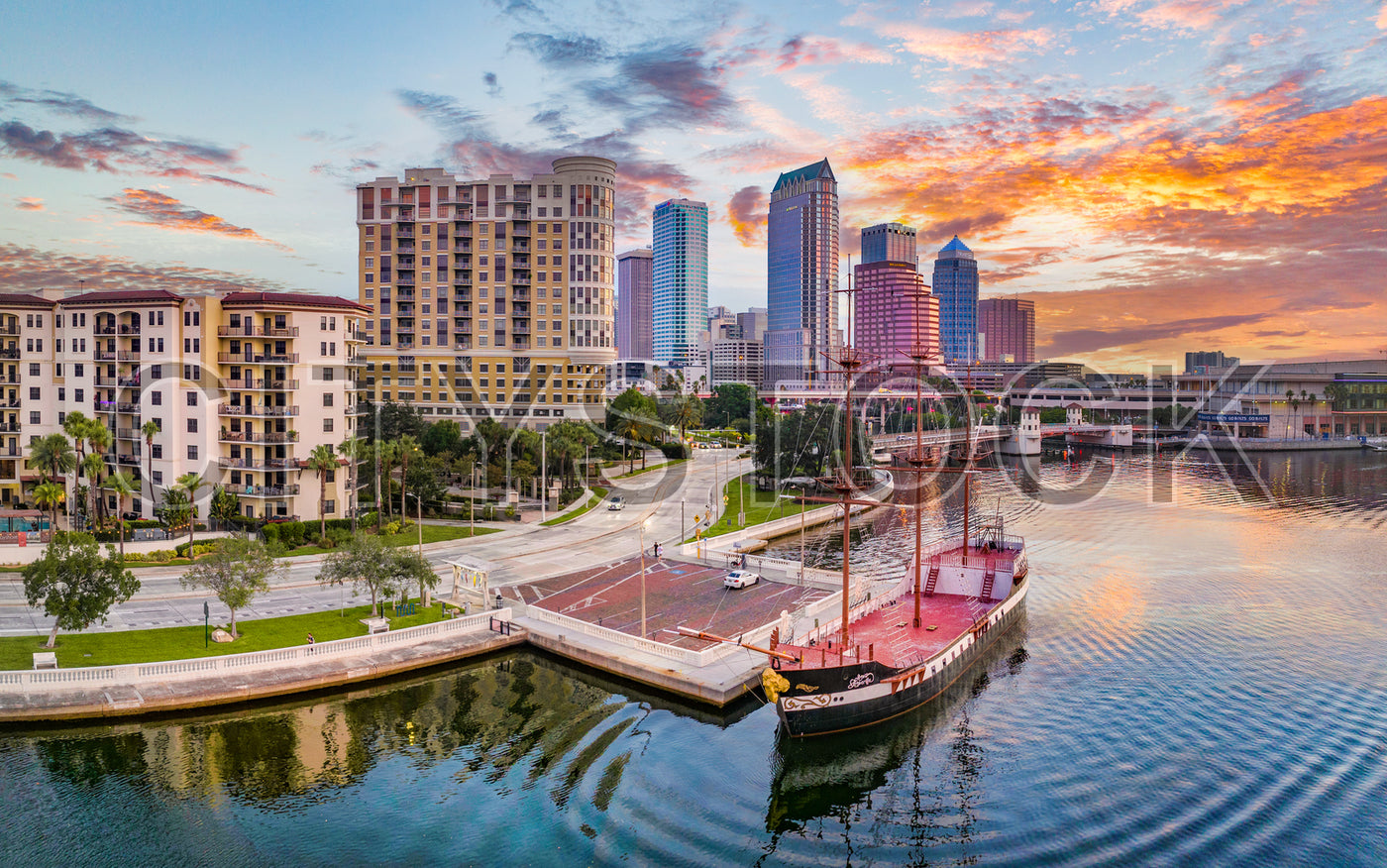 Sunset over Tampa Bay with a sailing ship and city skyline