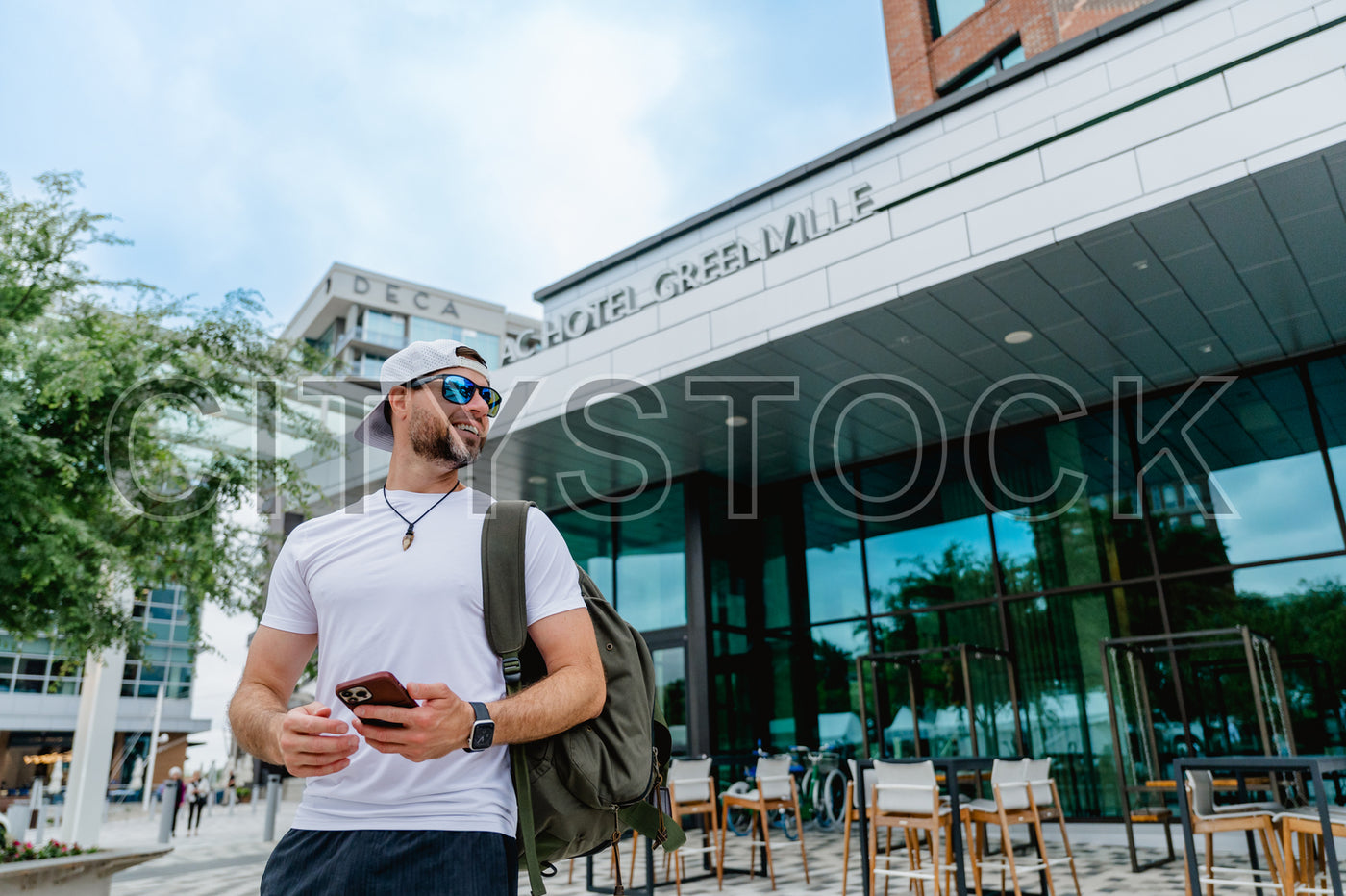 Young man using phone outside Deca Hotel in Greenville, SC