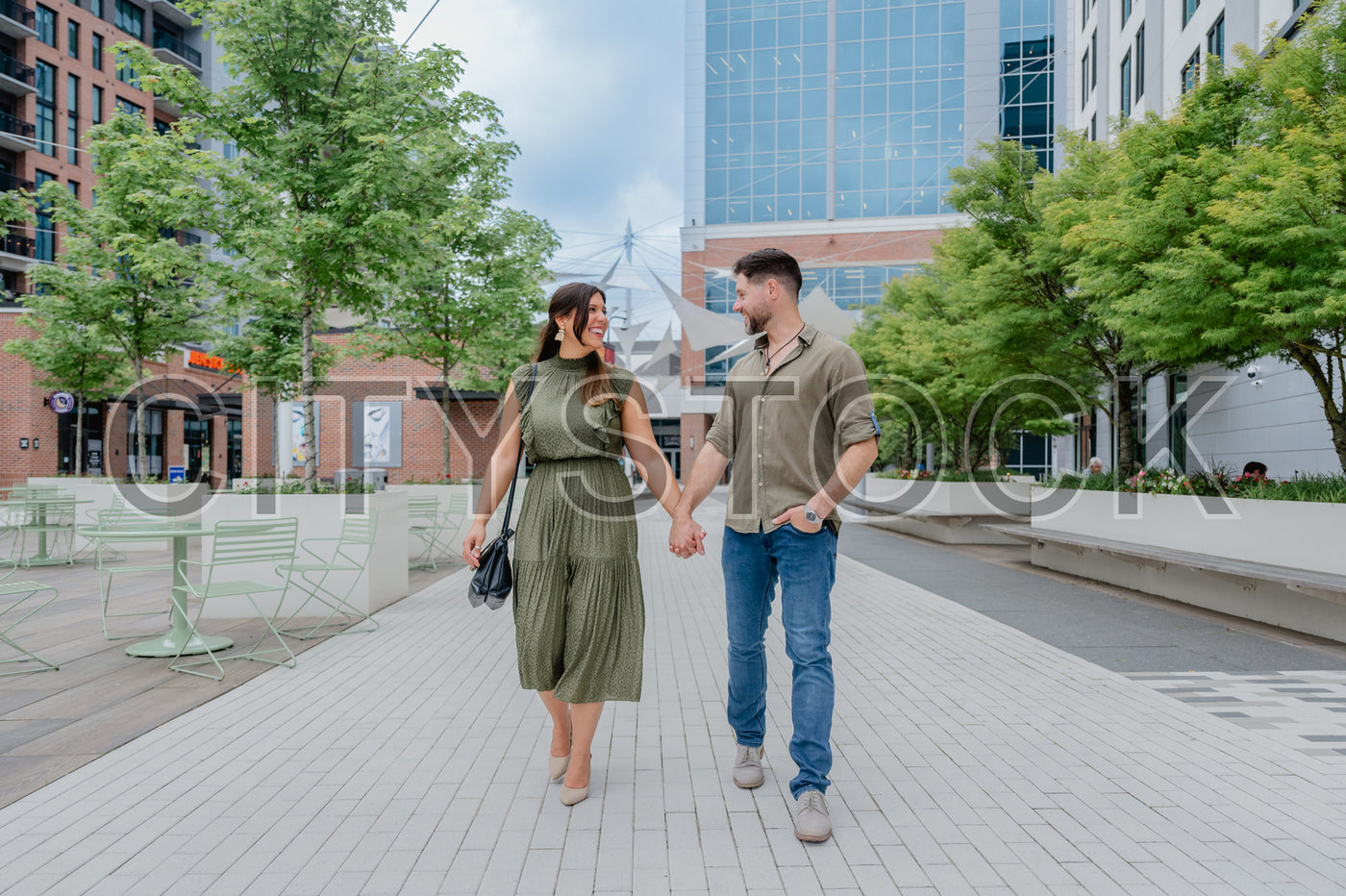 Couple hand-in-hand walking in Greenville urban park