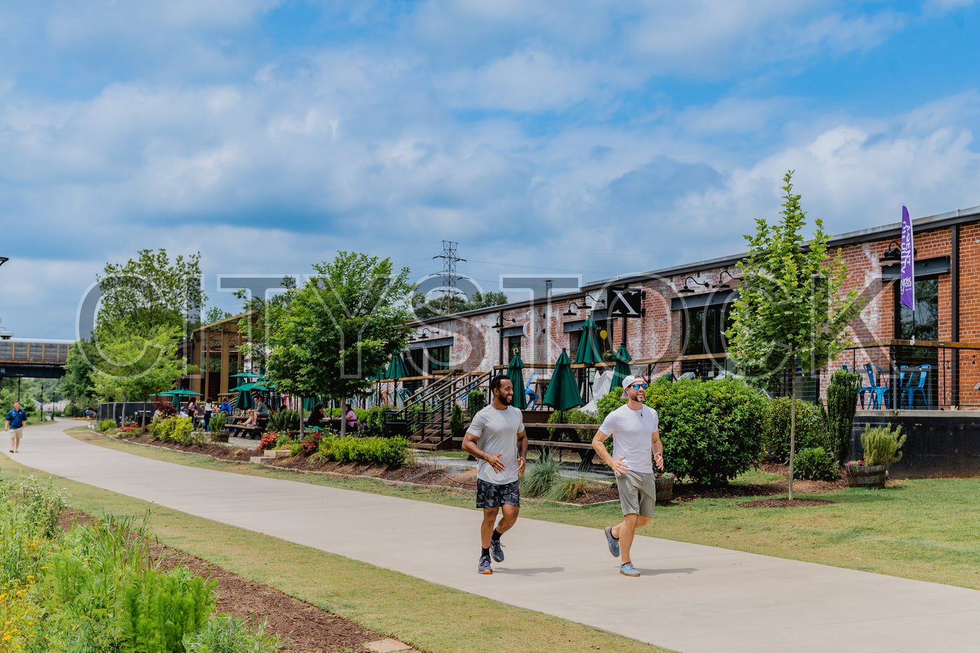 Two men jogging by historic brick buildings in Greenville, SC