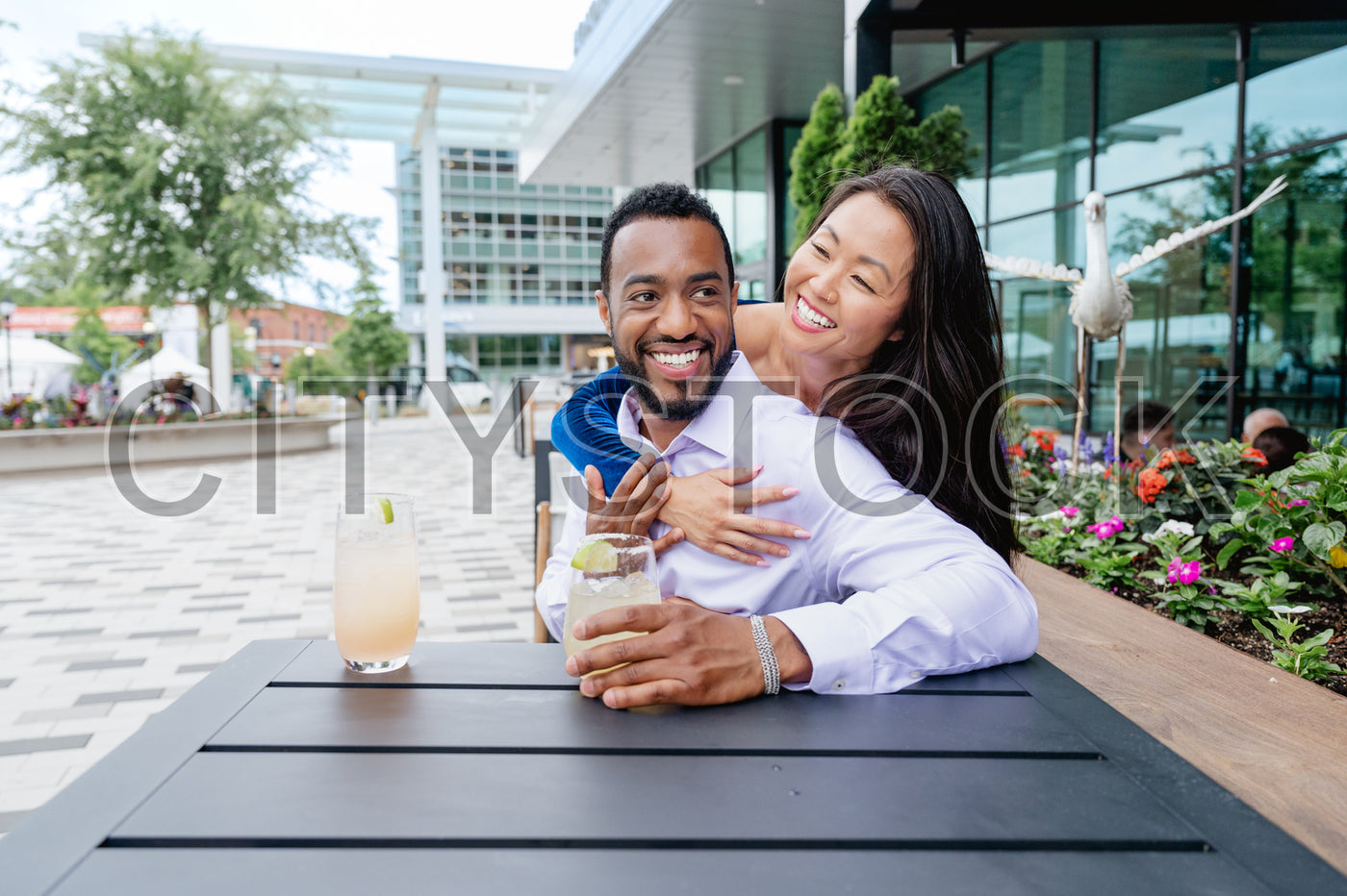 Young couple laughing and drinking at urban cafe in Greenville