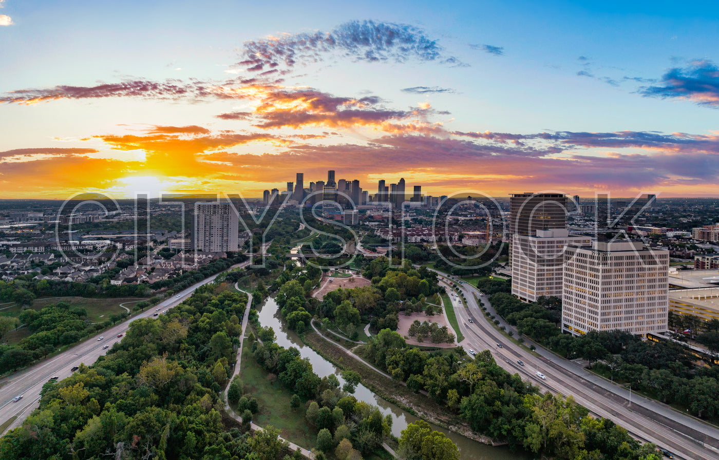 Panoramic sunset view of Houston skyline with highways and parks