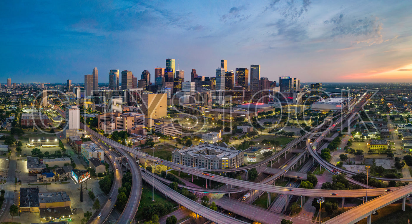 Aerial view of Houston skyline with freeway interchanges and sunset