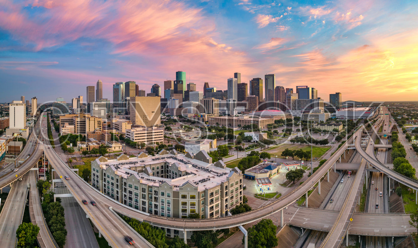 Houston skyline at sunset with colorful clouds over highways