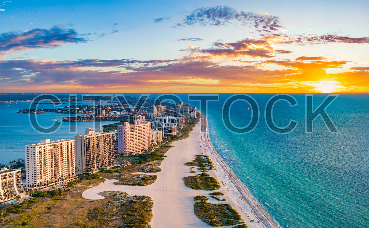 Aerial sunset view over Clearwater Beach, FL with urban skyline