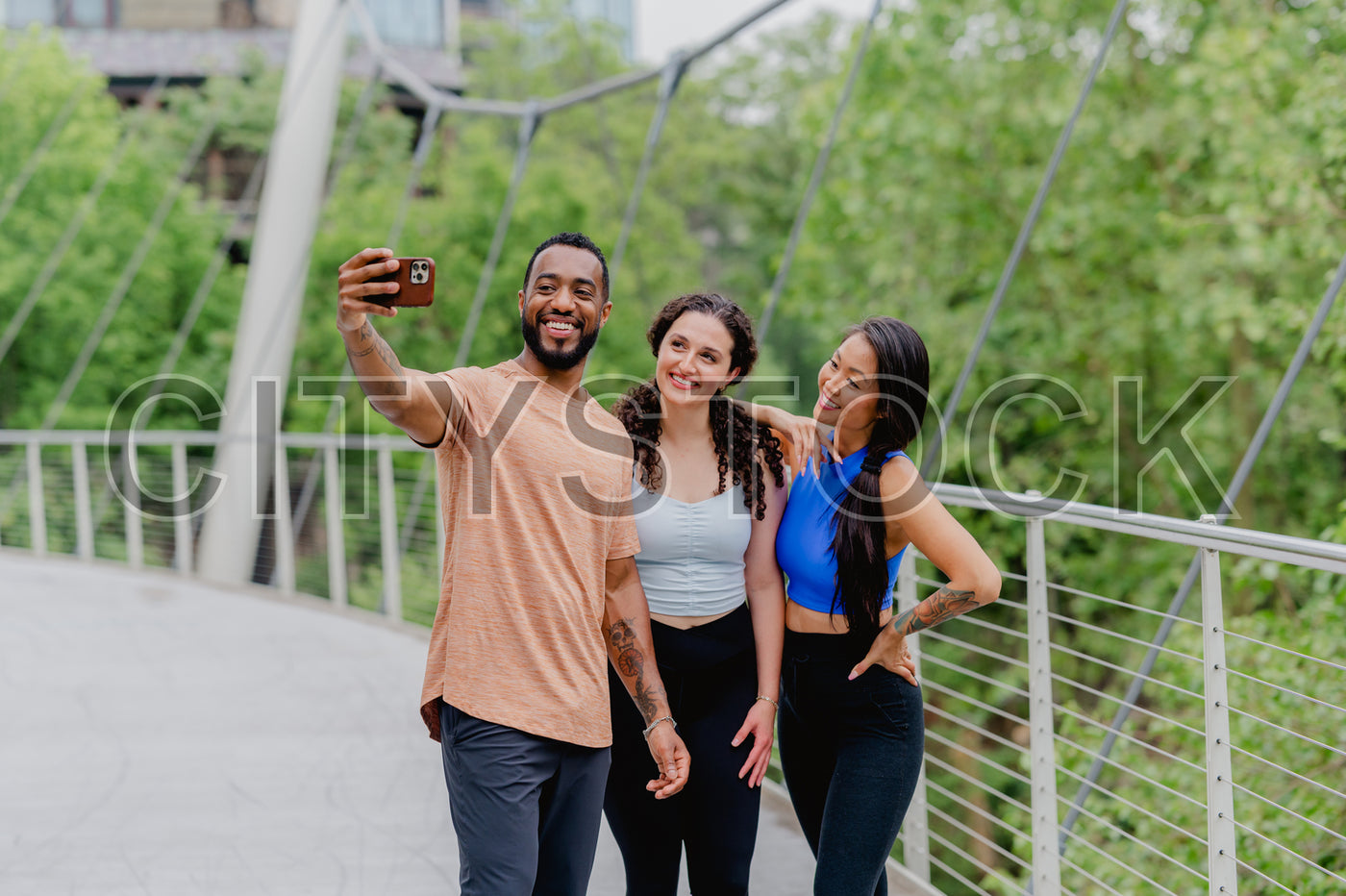 Multicultural friends taking selfie on Greenville bridge