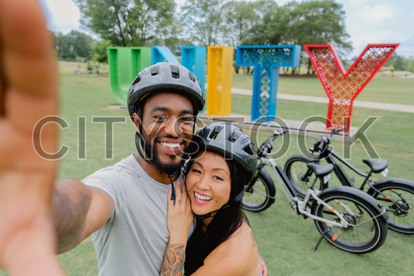 Smiling couple taking selfie at Unity Park, Greenville with bikes