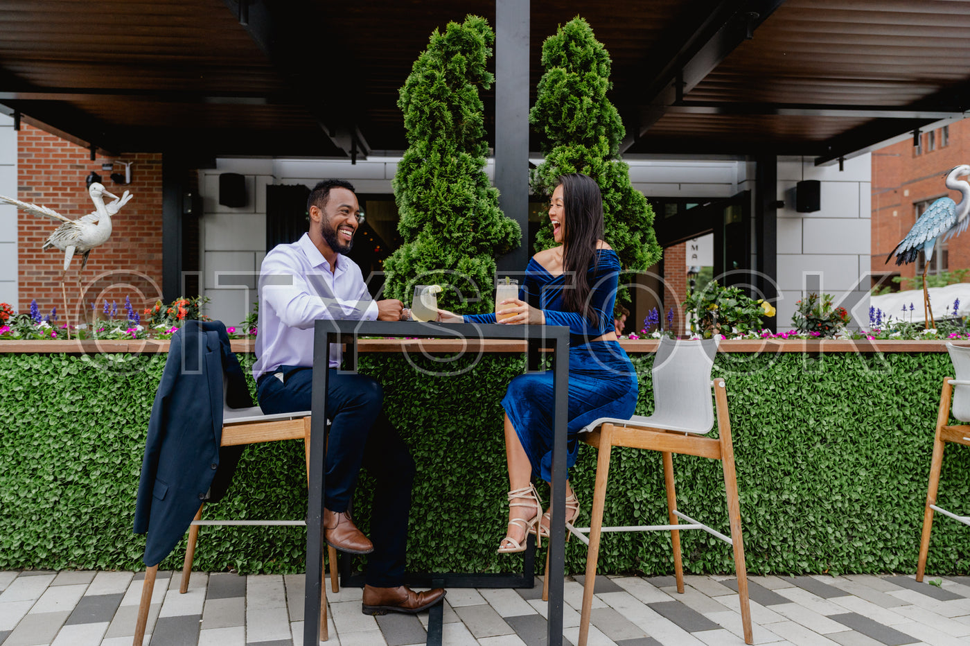 Joyful couple laughing at outdoor cafe in Greenville