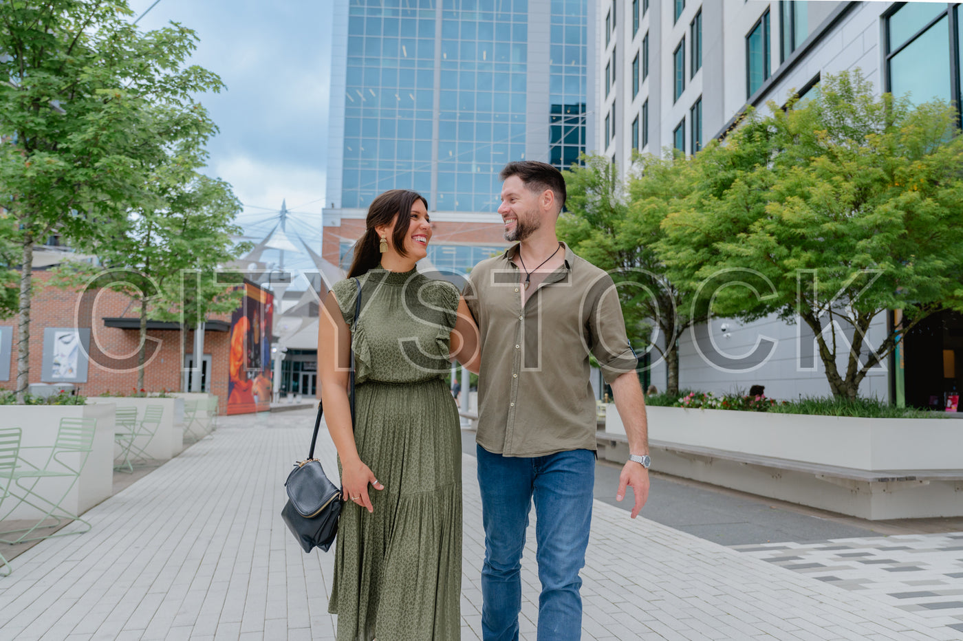 Happy couple walking and smiling in urban Greenville, SC