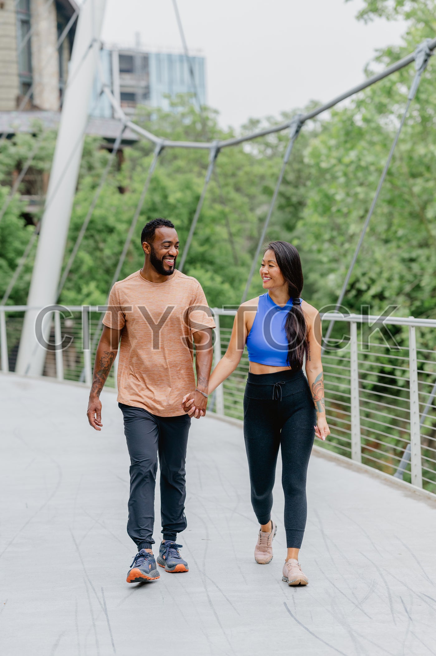 Joyful couple enjoying a walk on a modern bridge in Greenville