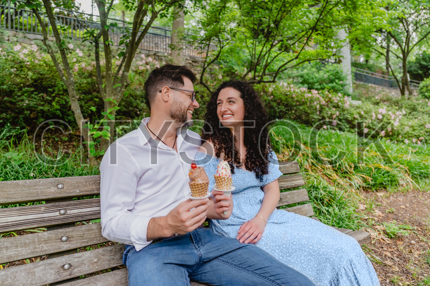 Couple laughing together with ice creams in Greenville park