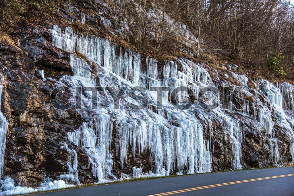 Stunning view of a frozen waterfall beside a road in Asheville, NC during winter