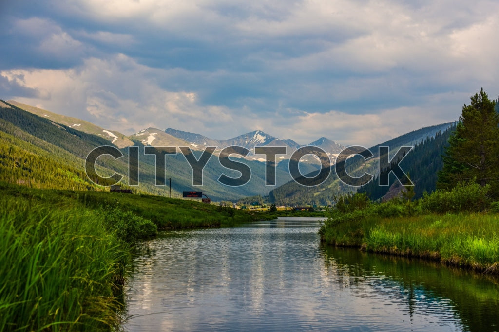 View of a tranquil Aspen lake with snowy mountains and blue sky