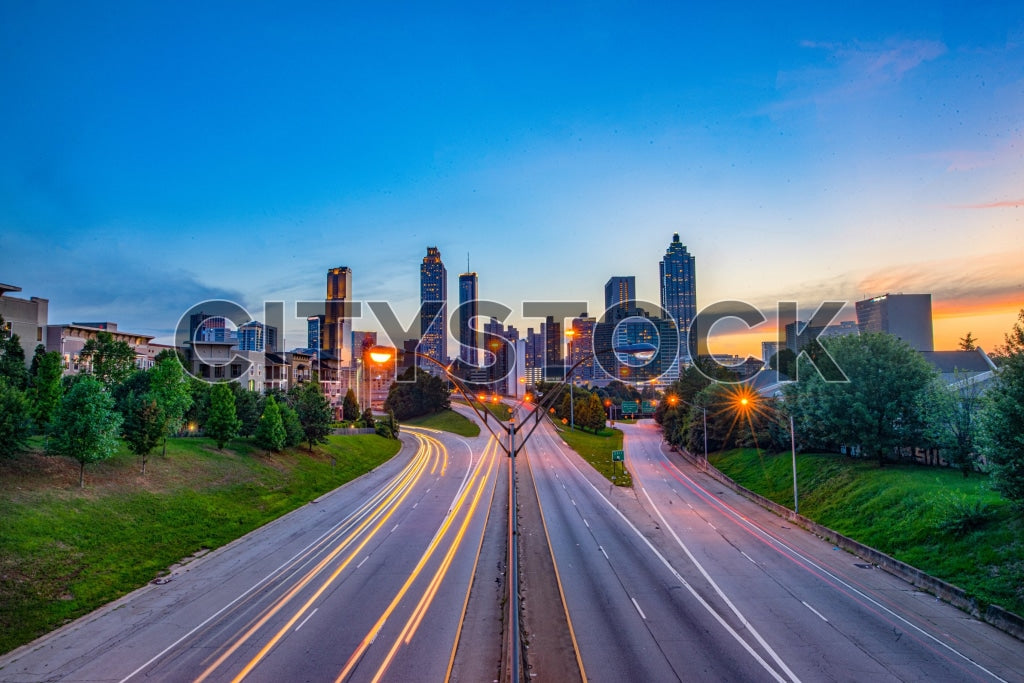 Atlanta skyline at sunset with colorful sky and light trails on street