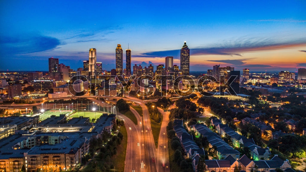Aerial view of Atlanta skyline during sunset, with lights and vivid sky