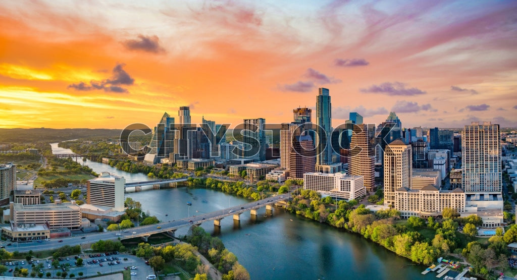 Sunrise lighting up Austin skyline with Lady Bird Lake in the foreground
