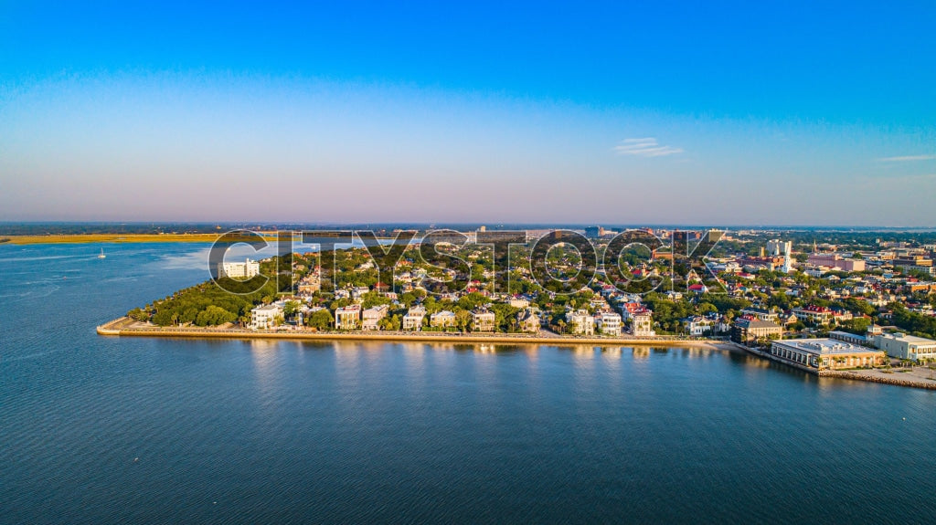 Aerial view of Charleston, SC waterfront on sunny day, showcasing urban landscape