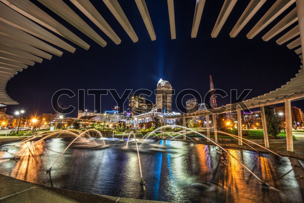 Charlotte cityscape at night, showcasing reflective water features and urban skyline
