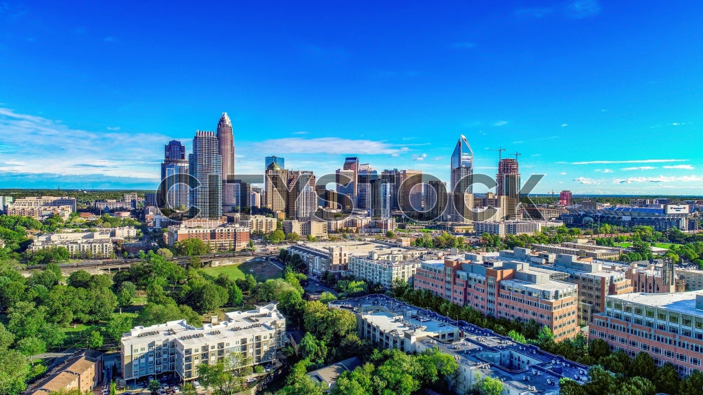 Aerial view of Charlotte NC, showing skyscrapers and green parks.