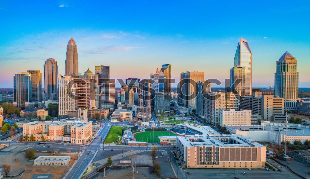 Aerial view of Charlotte skyline at sunrise, featuring high-rises
