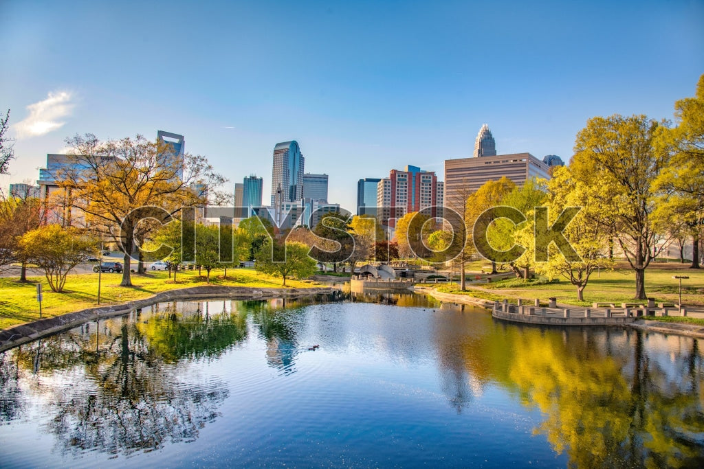 Charlotte NC Cityscape and Park Lake with Fall Colors and Blue Sky
