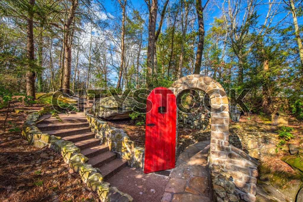 Chattanooga stone archway with a vibrant red door surrounded by lush forest