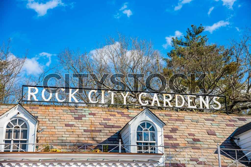 Rock City Gardens sign on a vintage building roof under blue sky