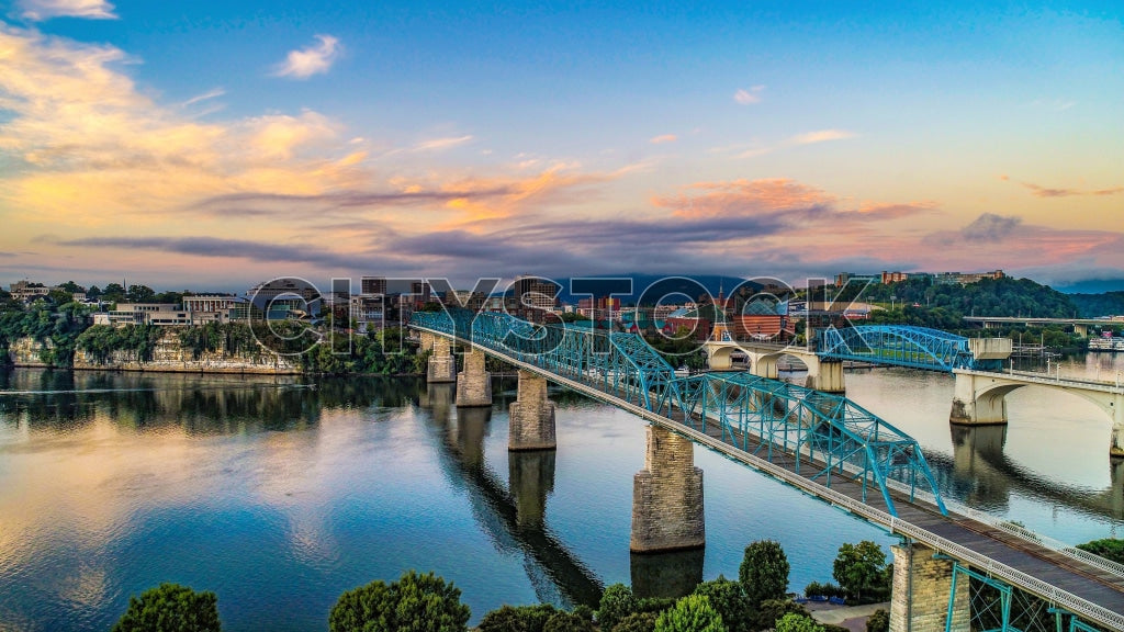 Chattanooga bridge at sunrise with cityscape and river reflection