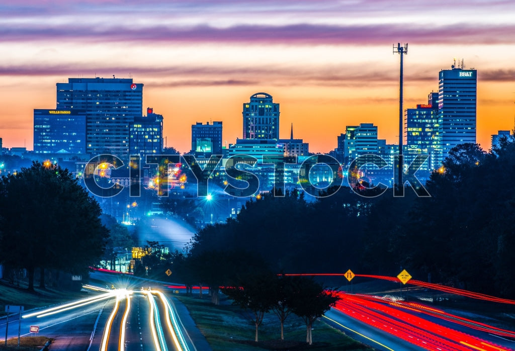 Columbia, SC cityscape at sunset with colorful sky and traffic light trails