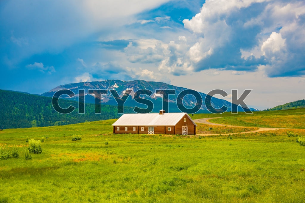 Rustic barn in green field with mountain background in Crested Butte