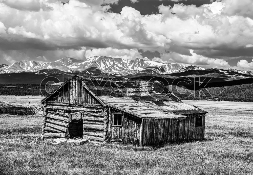 Black and white image of a rustic cabin in Crested Butte, CO with Rocky Mountains