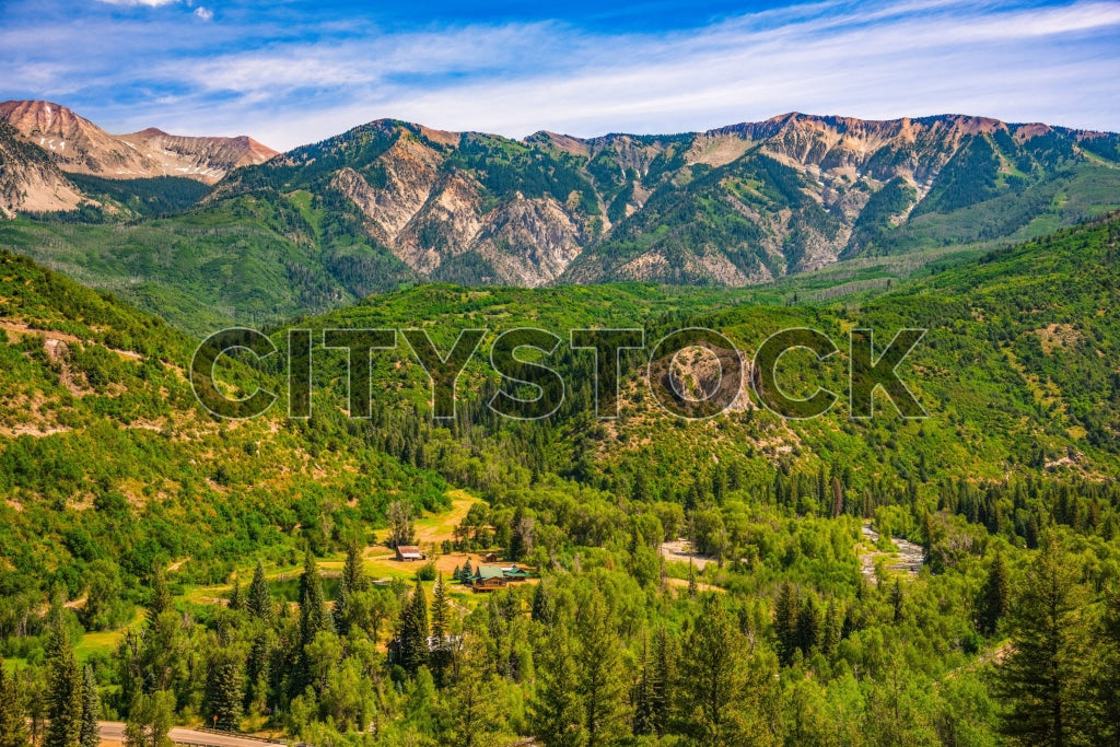 Panoramic scenic view of Crested Butte, green forests under blue sky