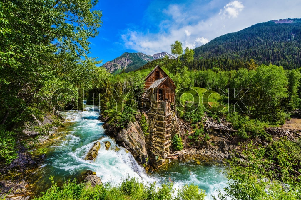 Historic Crystal Mill surrounded by lush green forest and blue river in Colorado