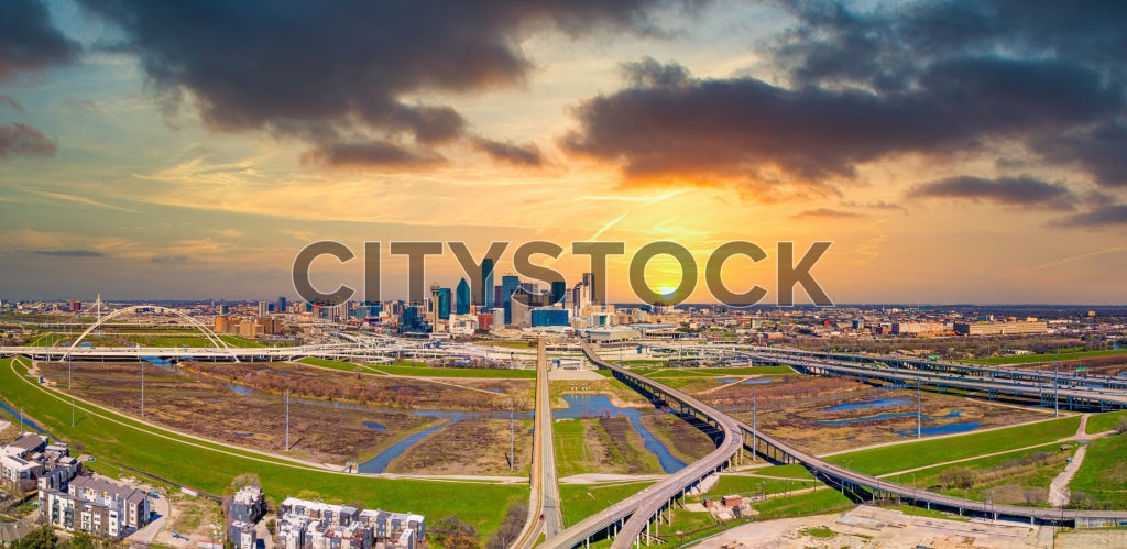 Aerial view of Dallas skyline at sunrise with colorful sky and highways
