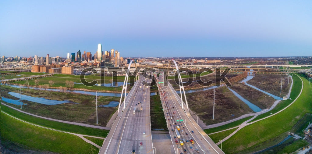 Aerial view of Dallas skyline at sunrise with highways and river