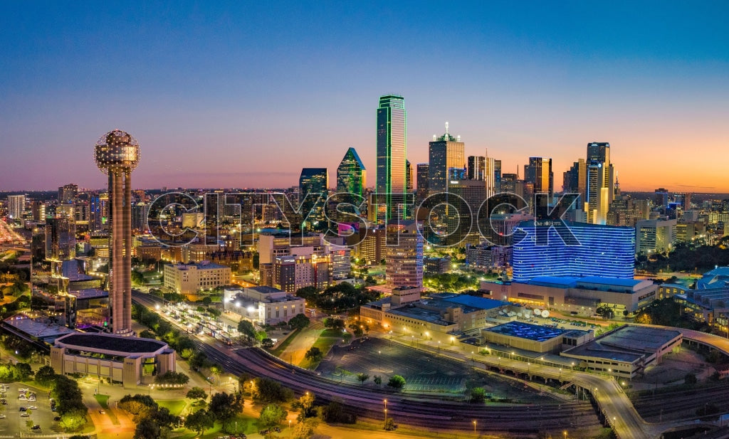 Aerial view of Dallas city skyline at sunset showing glowing lights